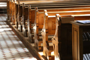 Row of wooden church pews in sunlight