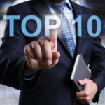 Business man in suit pointing finger at "Top 10" heading