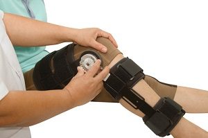 doctor adjusting patients knee brace