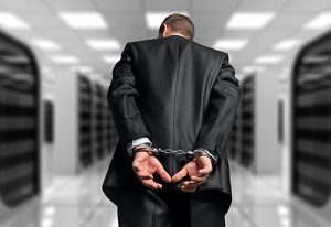 Handcuffed business-leader walking through jail.