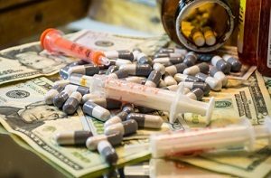 pills, syringes, and money scattered around