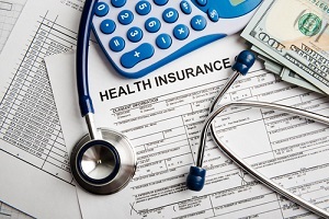 health insurance forms with stethoscope and calculator