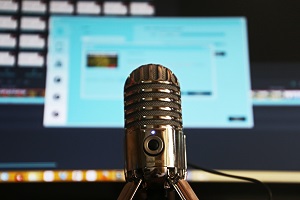 podcast microphone in front of computer monitor