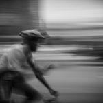 Bicycle messenger blurred by speeding on street