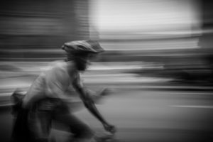 Bicycle messenger blurred by speeding on street