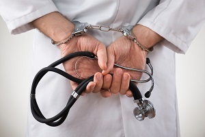Doctor in handcuffs holding a stethoscope