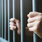 Person holding prison bars