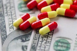 Red and yellow pills scattered on hundred dollar bills