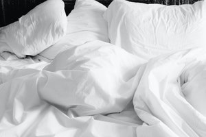 bed with pillow and sheets scattered