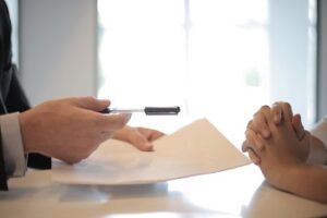 Businessman Giving Contract to Person to Sign