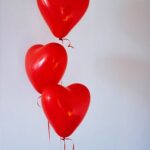 Three Red Heart Balloons Floating