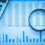 magnifying glass over financial reports and data